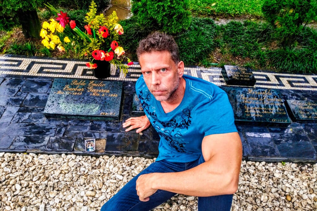 Eric sitting next to Pablo Escobar’s grave in Itagüí, Antioquia Colombia just outside Medellín on a cloudy, wet day.
