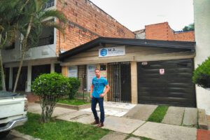 Eric is standing next to a real estate business that is on one side of the building where Pablo Escobar was killed on December 2, 1993, on the barrel tiled roof in Medellín, Antioquia Colombia.