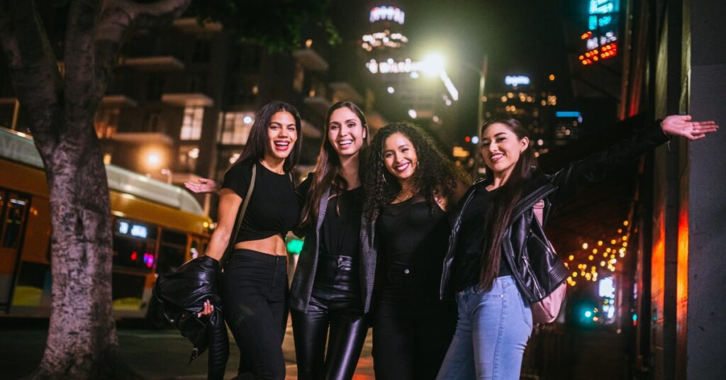 4 dark haired Latinas smiling on a night out in Los Angeles, California, United States.