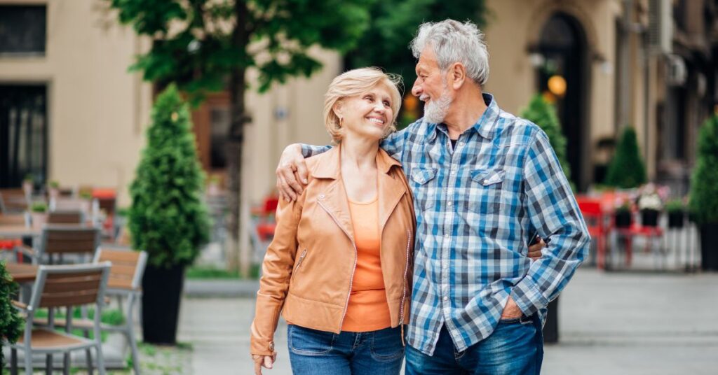 Older couple moving abroad embracing talking a walk on what appears to be a nice day.