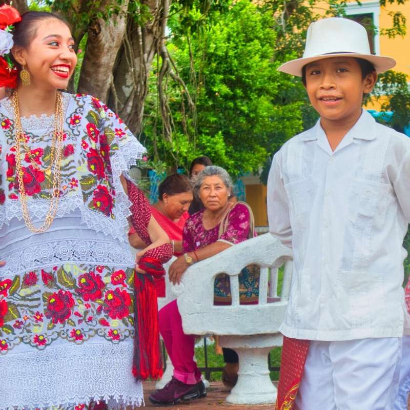 A young female and male jarana dancer are smiling at Parque Francisco Canton Rosado in Valladolid, Yucatán, Mexico.