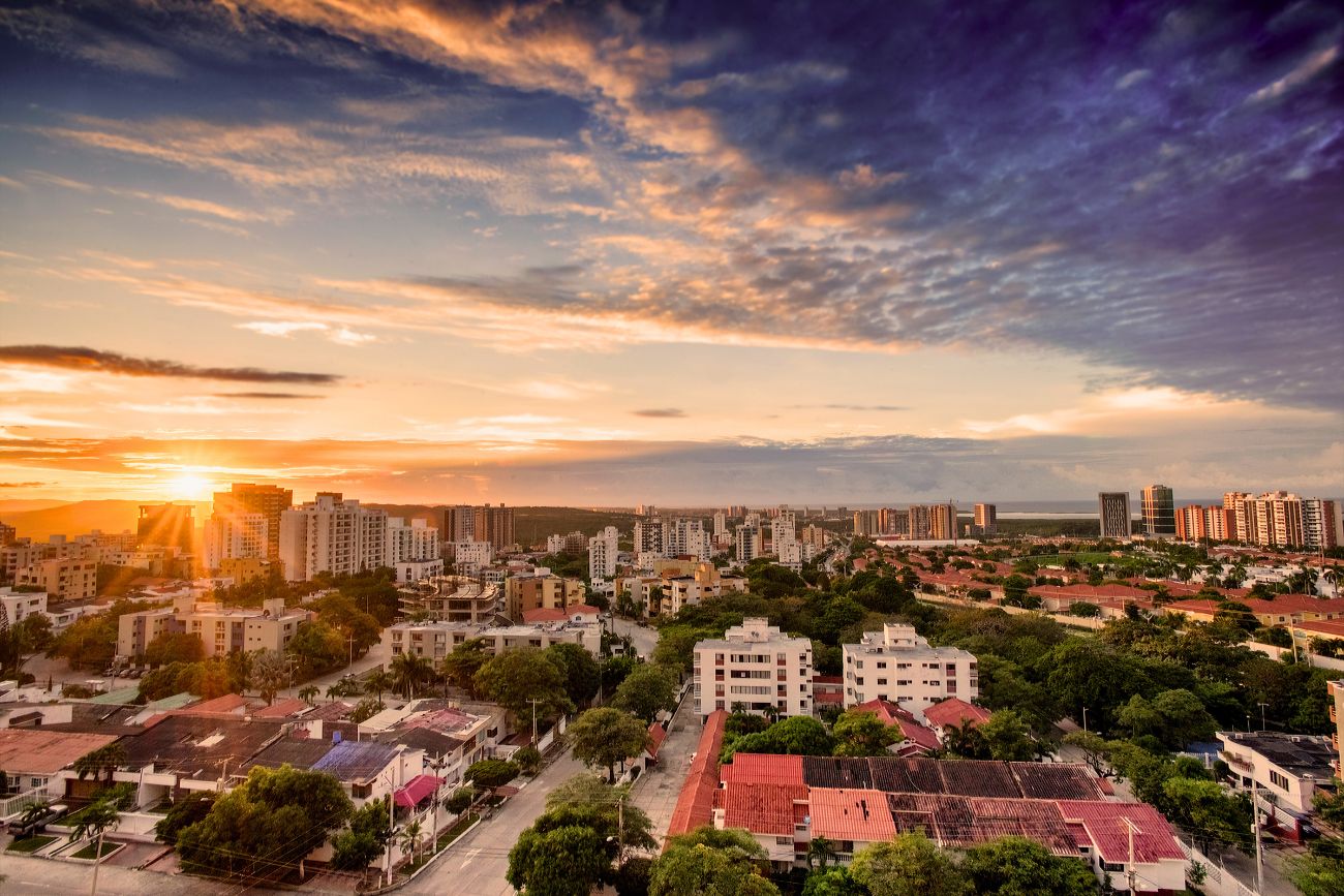 Aerial cityscape with a mix of white and brick-red colored buildings at sunset in Barranquilla, Atlántico, Colombia.