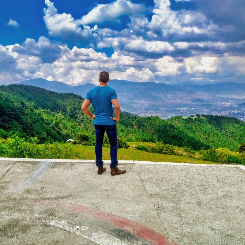 Eric with back turned looking down at the city at La Catedral, Pablo Escobar's former prison, now a senior living facility in Envigado, Antioquia, Colombia.