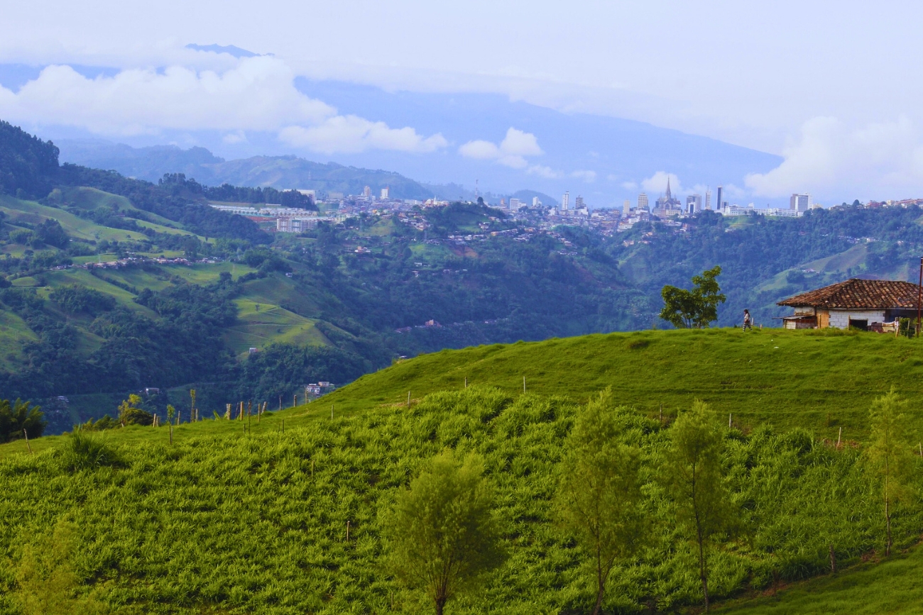 Verdant hills in eje cafetero (coffee axis) with the city far in the background on a cloudy day in Manizales, Caldas, Colombia.
