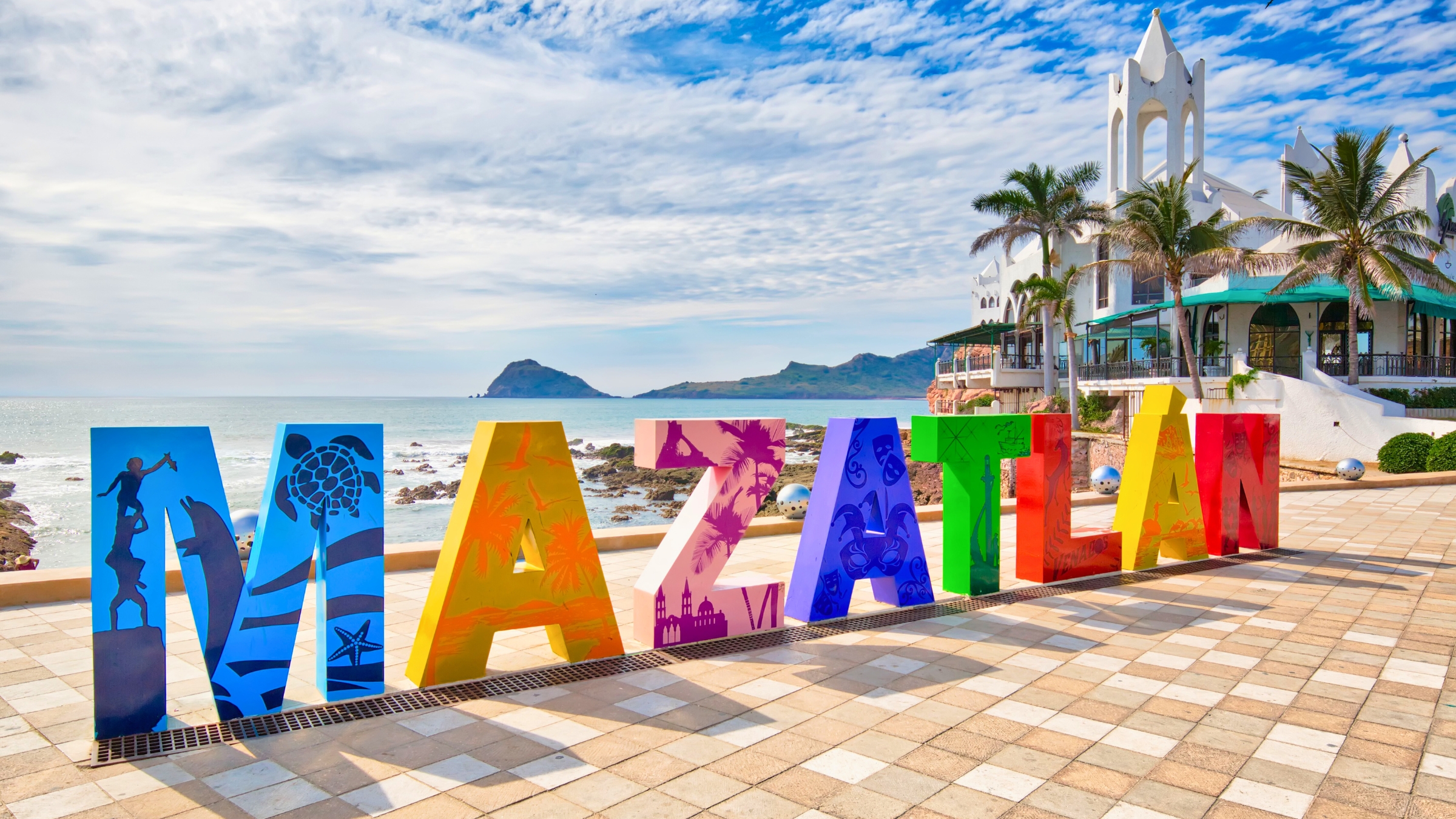 The multicolored Mazatlán sign on a partly cloudy day on the malecón in Mazatlán, Sinaloa, Mexico.