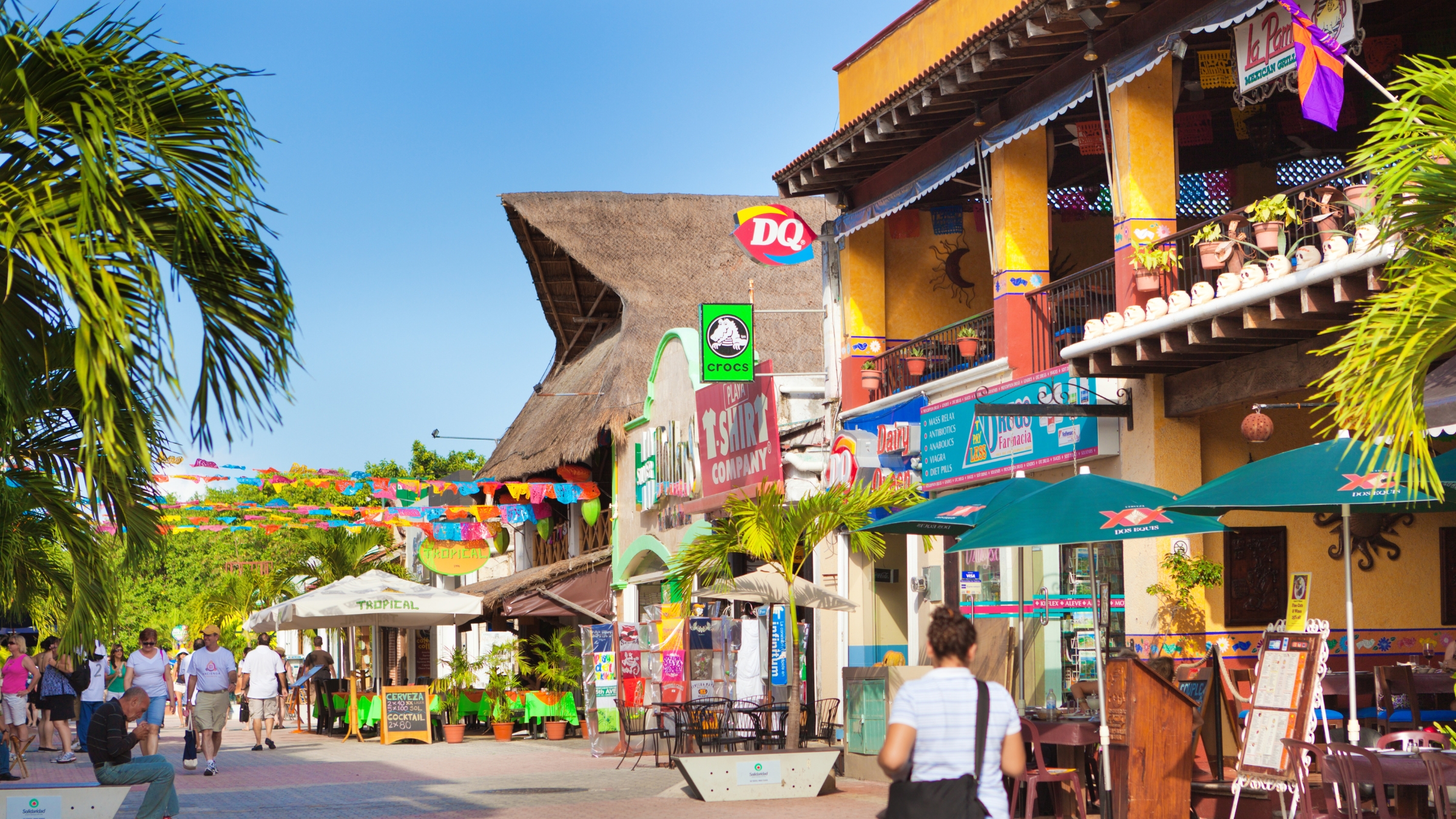 Pedestrian only Quinta Avenida on a clear sunny day showing pedestrians and storefronts including DQ or Dairy Queen in Playa del Carmen, Quintana Roo, Mexico.
